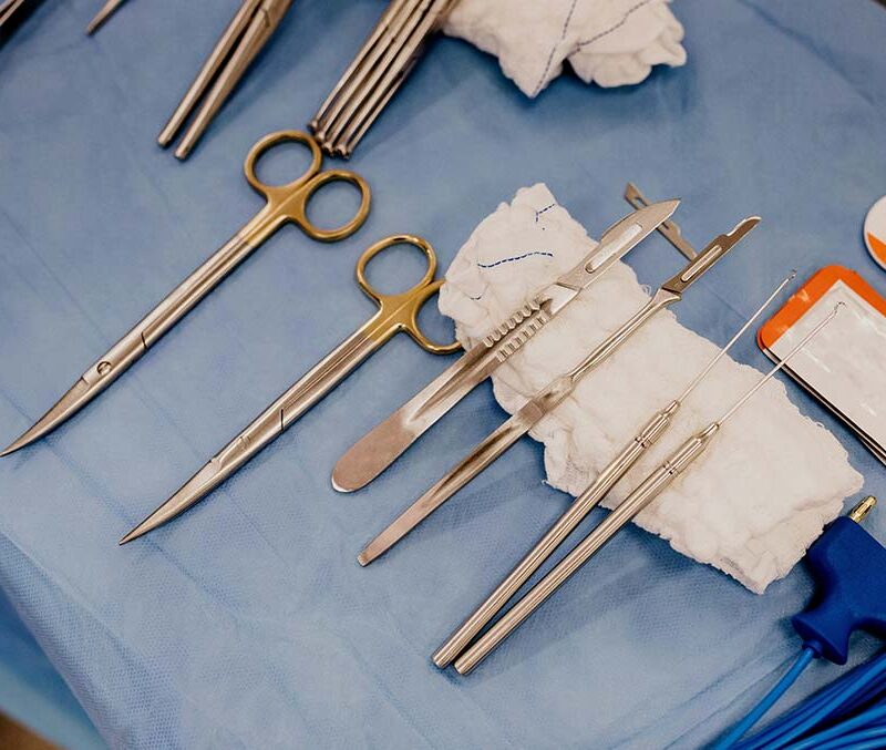 A set of surgical scissors on a tabler with a blue background