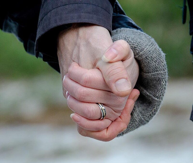 A photo of two people holding hands.