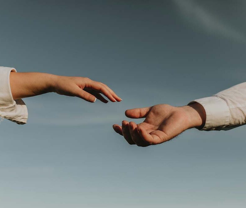 Two hands reaching out to touch.